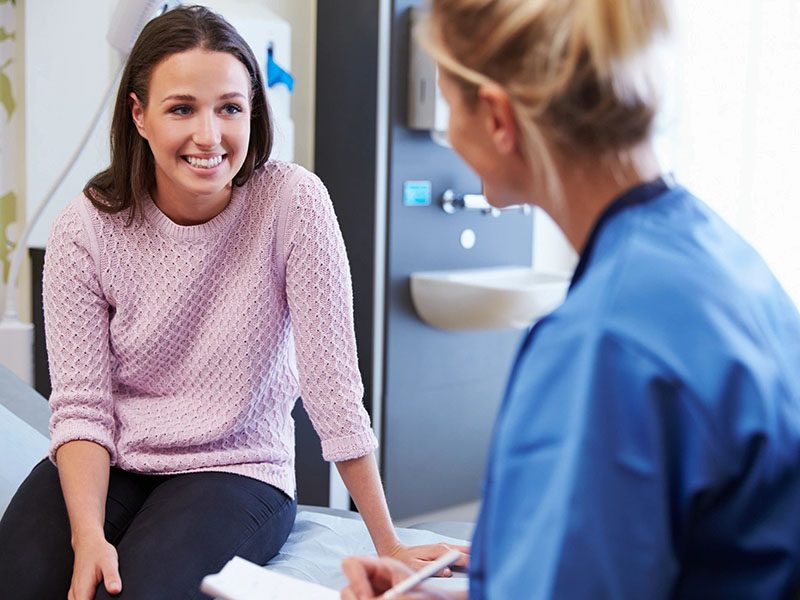 Girl Talking to Nurse in Hospital Room wearing a purple dress