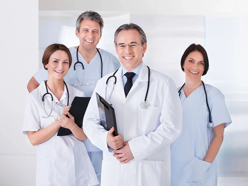 Male Doctor Standing in Front of Team Using Digital Tablet